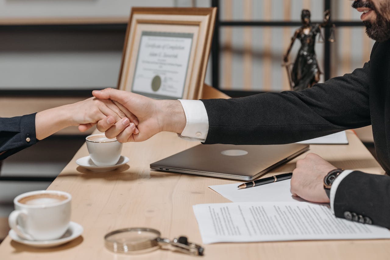 services-03 A formal handshake over a business contract in a corporate office setting.